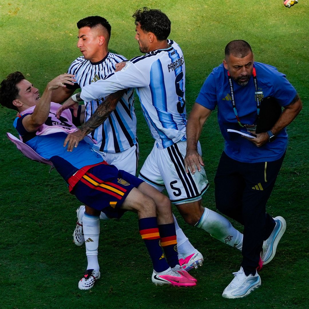 El jugador español Gavi, a la izquierda, es empujado en un choque con el jugador argentino Leandro Paredes y Thiago Almada. Foto: AP